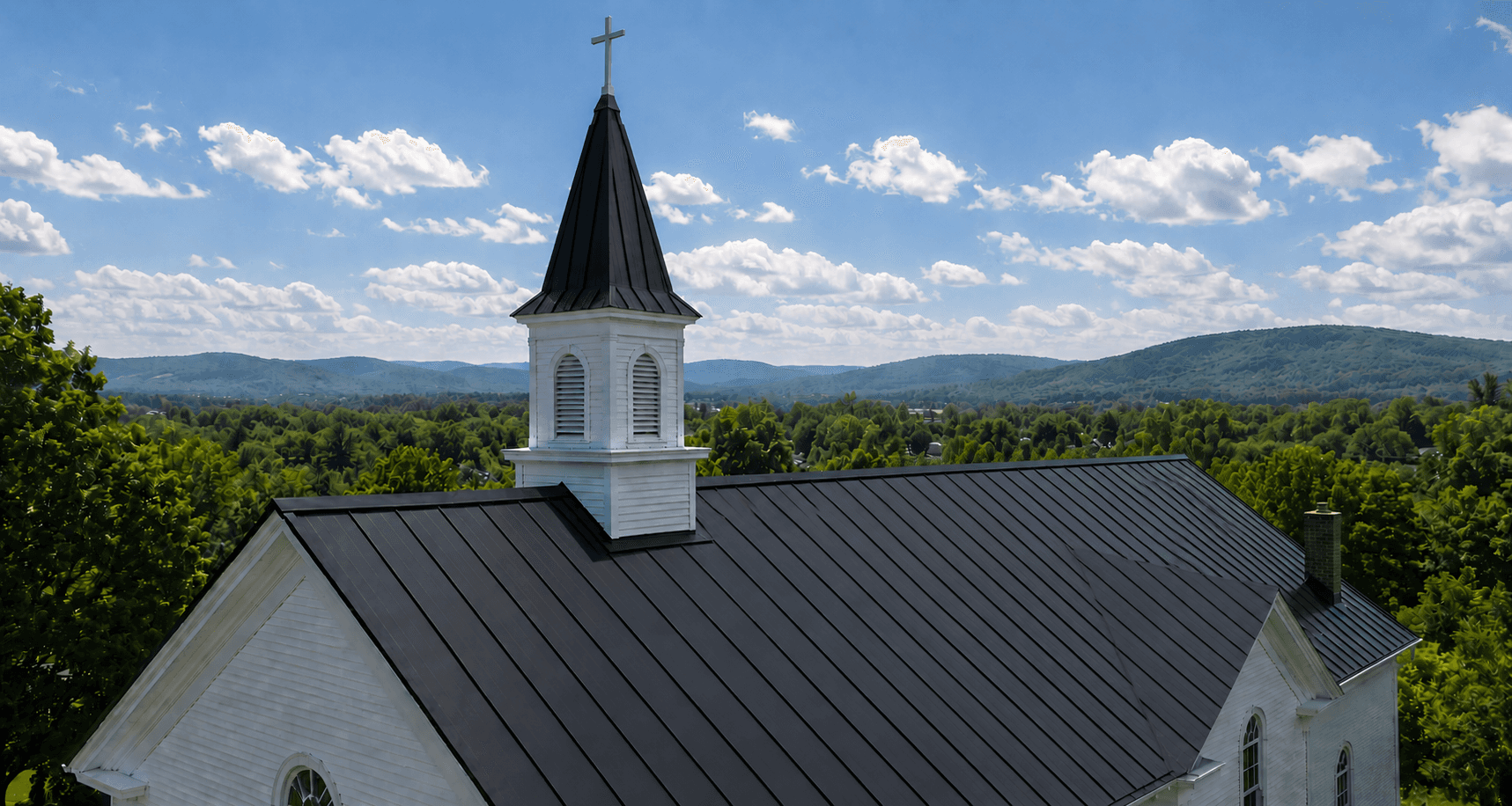 Standing seam metal roof in Vermont with Green Mountains in background